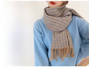 Close-up of thick knit clover pattern scarf with tassels in blue and yellow
