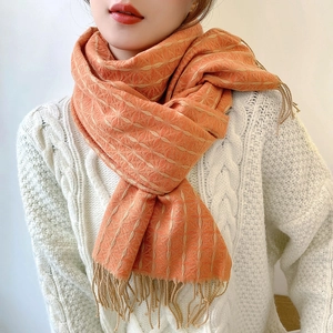 Winter cashmere-like shawl with orange clover pattern and fringe worn over white sweater