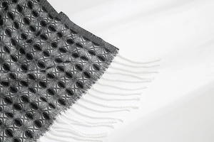 Detailed view of winter cashmere feel scarf featuring honeycomb weave and white tassels
