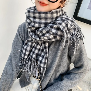 Classic black and white plaid scarf with tassels on a model for winter style