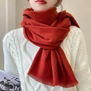 Red cashmere feel scarf with fine tassel edge paired with a warm cable knit sweater