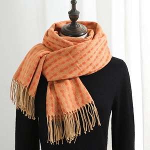 Orange cashmere-like scarf with clover patterns and soft tassels on a mannequin