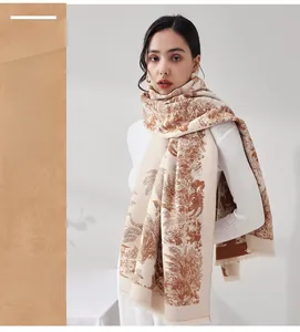 Detail eines dicken Jacquard-Schals mit beigebraunem Blumenmuster und Fransen