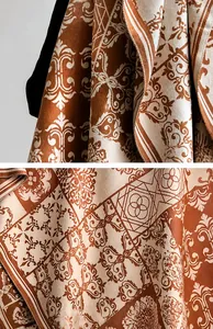 Macro shot of luxury cashmere-feel scarf showing baroque floral patterns and fine stitching