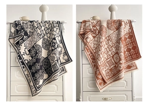 Detailed view of luxury scarves with baroque patterns draped over a white dresser