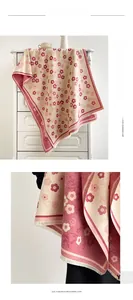 Detailed macro view of the cream floral pattern and soft fringes on this cashmere scarf