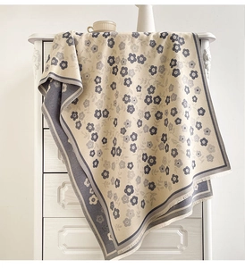 Detail of floral cashmere-like scarf with fringe on a white vintage cabinet