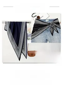 Detail of dark blue scarf with geometric ethnic border showing silky texture and drape