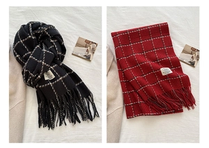 Detail of red and black plaid scarves with tassel edges and thick faux cashmere texture