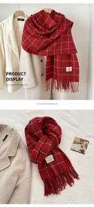 Detail of red plaid cashmere-like scarf showing soft texture and fringe tassels