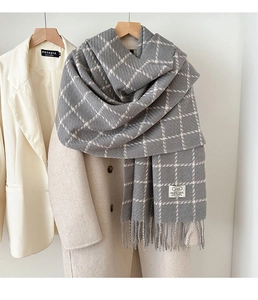 Detail of grey checkerboard scarf with tassels showing thick faux cashmere texture