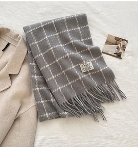 Close-up of grey plaid scarf with fine white lines and woven zian brand label detail