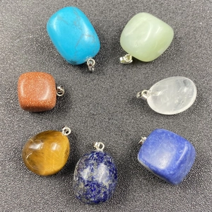 Lot de sept pendentifs en pierres naturelles irrégulières avec clips argentés sur fond noir