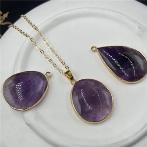 Vue macro de pendentifs en améthyste violette en forme de goutte avec bordure dorée
