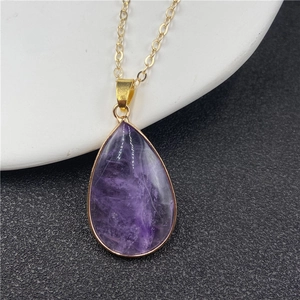 Élégant pendentif améthyste goutte d'eau violette avec bord doré sur une chaîne fine