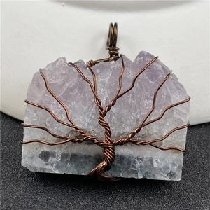Macro shot of handmade wire-wrapped tree of life pendant with amethyst raw stone