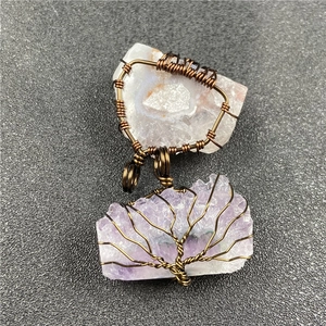 Detailed close-up of handmade Tree of Life wire-wrapped amethyst and quartz pendants