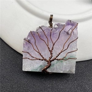 Close-up of handmade tree of life wire wrapping on purple amethyst pendant