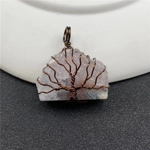 Macro detail of handmade amethyst tree of life pendant with copper wire wrapping
