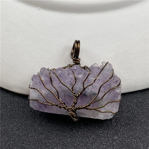 Detailed view of handmade copper wire tree of life wrapped around natural amethyst gemstone