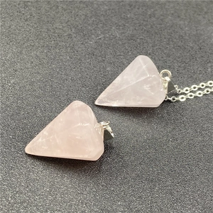 Macro view of a pyramid-shaped rose quartz crystal pendant with a sleek silver chain