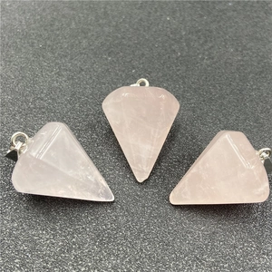 Macro view of three hexagonal rose quartz crystal pendants with silver metal bails