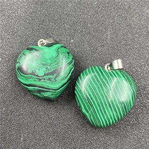 Detailed view of heart-shaped malachite pendants with natural green veined textures