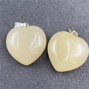 Macro view of two 30mm yellow crystal heart pendants with silver metal clasps