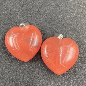Macro shot of two heart-shaped orange crystal pendants with natural ice textures