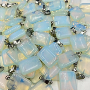 Close-up of bulk rectangular opalite pendants with iridescent blue and orange light effects