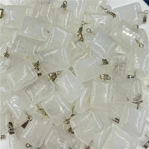 Macro shot of bulk rectangular clear quartz crystal pendants with silver bail connectors