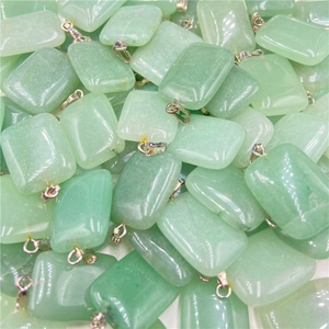 Macro view of stacked rectangular natural green quartz stone pendants with metal bails