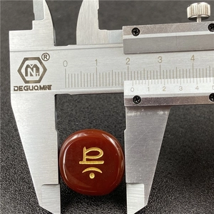 Macro shot measuring 18mm carnelian bead with golden symbol using stainless steel caliper