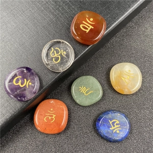 Detailed view of seven chakra energy stones with hand-engraved golden spiritual symbols