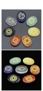 Detailed view of seven polished chakra stones with gold engraved geometric symbols