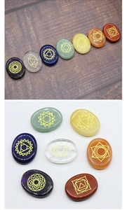 Detailed view of seven chakra polished natural stones with gold engraved symbols