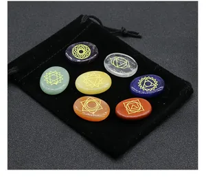 Detailed view of seven chakra energy stones with gold symbols and black velvet pouch