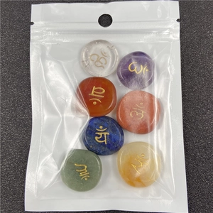 Detailed view of seven chakra energy stones with gold symbols in clear zipper bag