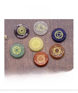 Detailed view of seven chakra energy stones with golden engraved symbols on wood