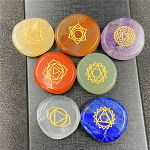 Macro view of seven chakra energy stones with gold engraved symbols on natural crystals
