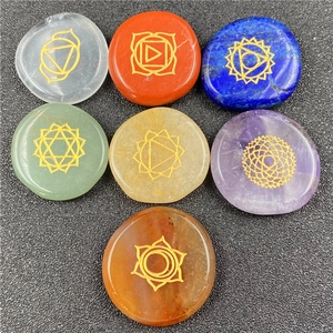 Set of 7 chakra healing crystals with golden engraved yoga symbols on polished natural stones