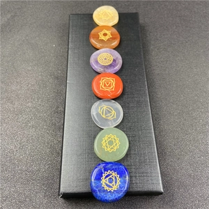 Detail of seven chakra healing stones with golden symbols in a black display box