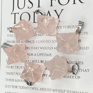 Detailed view of six rose quartz merkaba star pendants with silver bails on a card