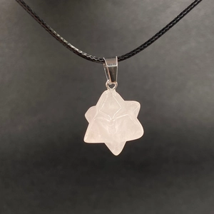 Macro detail of hexagonal rose quartz Merkaba pendant with silver clasp and black cord