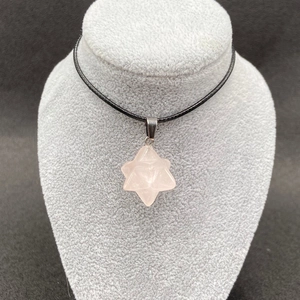 Detail of rose quartz Merkaba star pendant with natural pink crystal on black cord