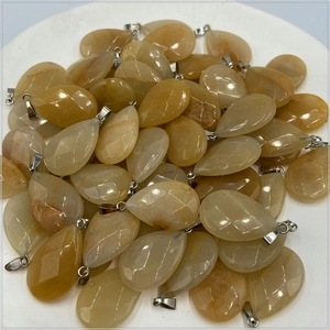 Macro view of faceted teardrop pendants in yellow natural stone with silver metal clasps