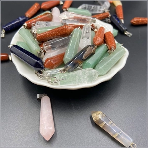 Close-up of assorted hexagonal crystal and natural stone pendants in a display tray