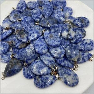 Macro view of teardrop crystal pendants with blue and white marble textures and silver clips