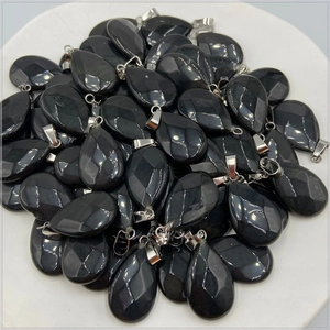 Macro view of teardrop black obsidian pendants with faceted finish and silver clips