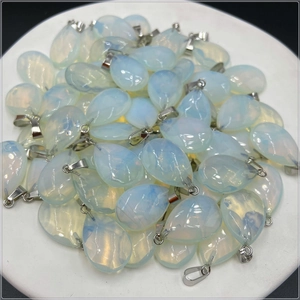 Close-up of teardrop faceted white opal pendants with silver metal clasps for DIY jewelry